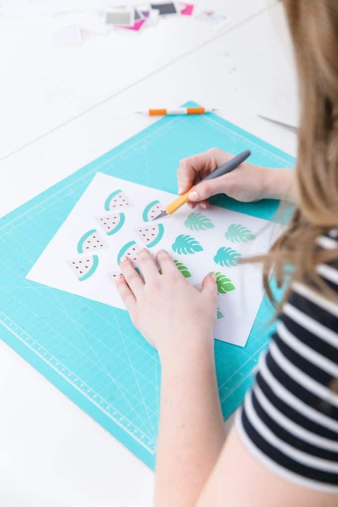 Cutting watermelon printable cupcake toppers with an exacto knife.