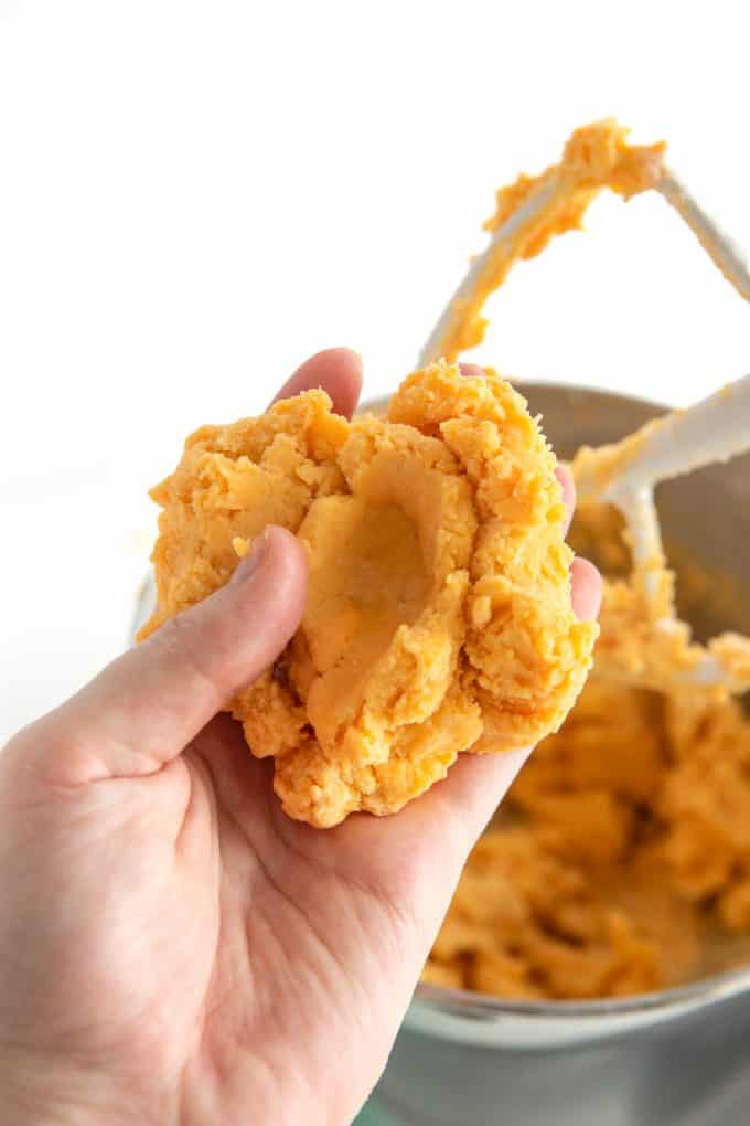 Hand holding cheese dough for homemade cheese crackers