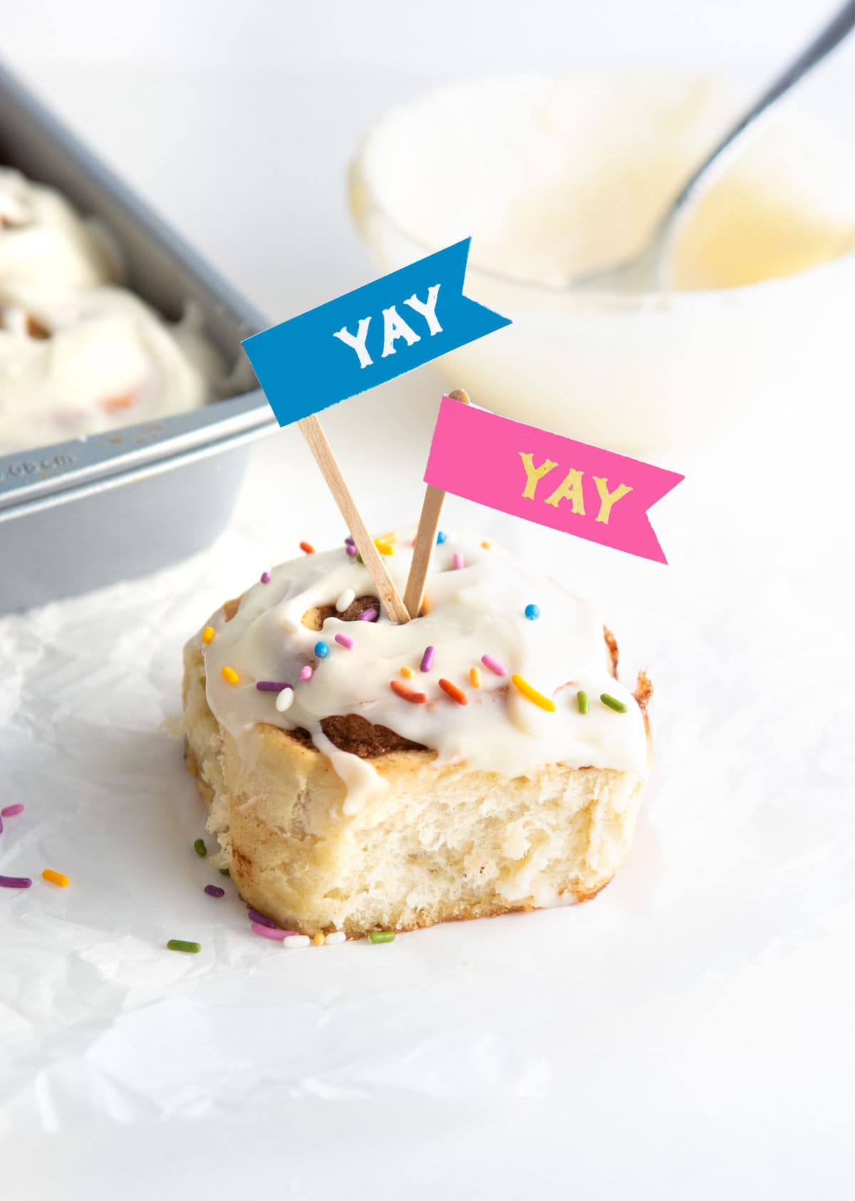 Cinnamon roll with rainbow sprinkles and yay treat toppers