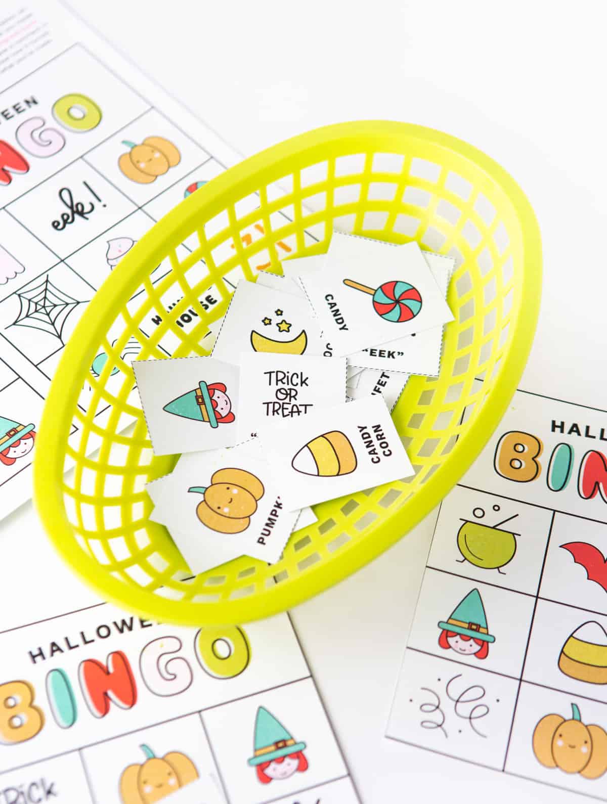Basket of Halloween bingo cards calling cards with icons and pictures: pumpkin, witch, lollipop, cauldron, spider, ghost