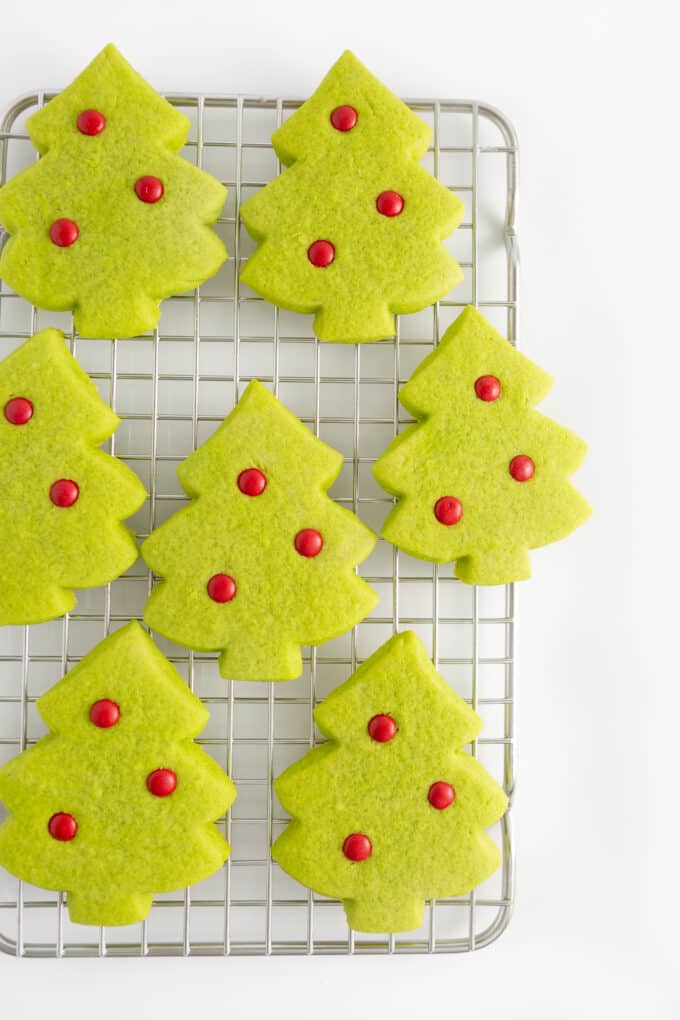 cooling rack of green christmas tree sugar cookie with red M&M ornaments