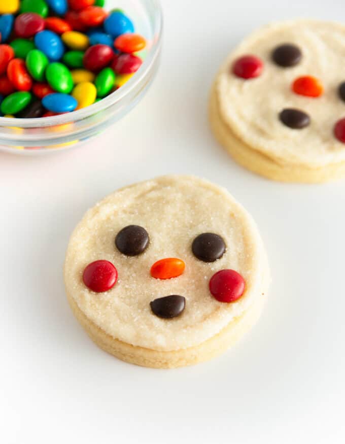 white snowman sugar cookie face decorated with M&M