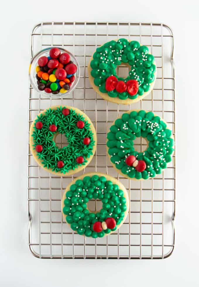 cooling rack of green decorated wreath cookies
