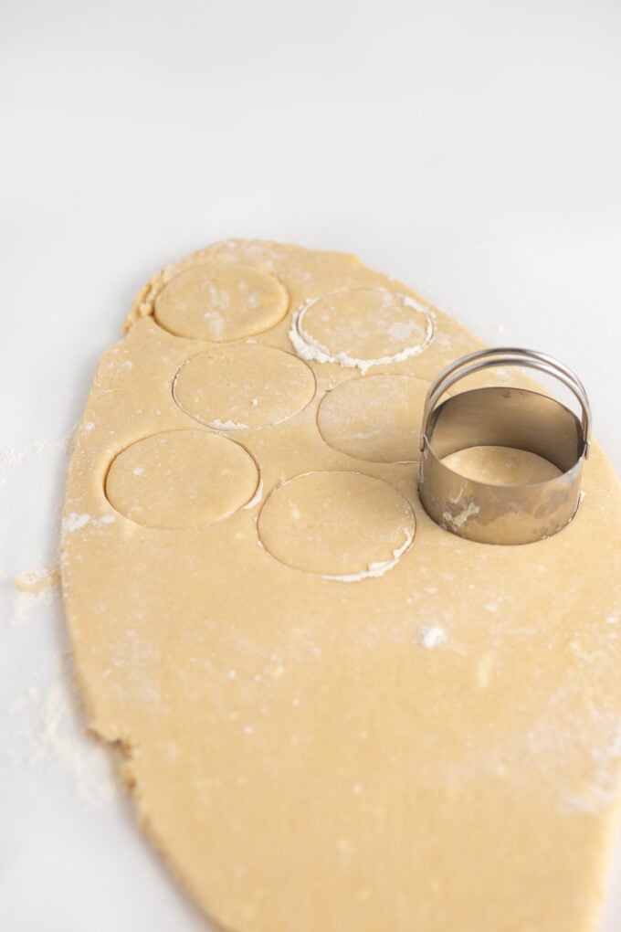 cutting sugar cookie dough with round cookie cutter