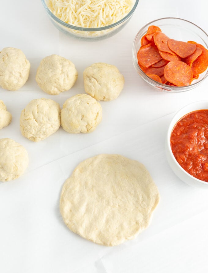 rolling dough into 8 balls and flattening into thin crusts