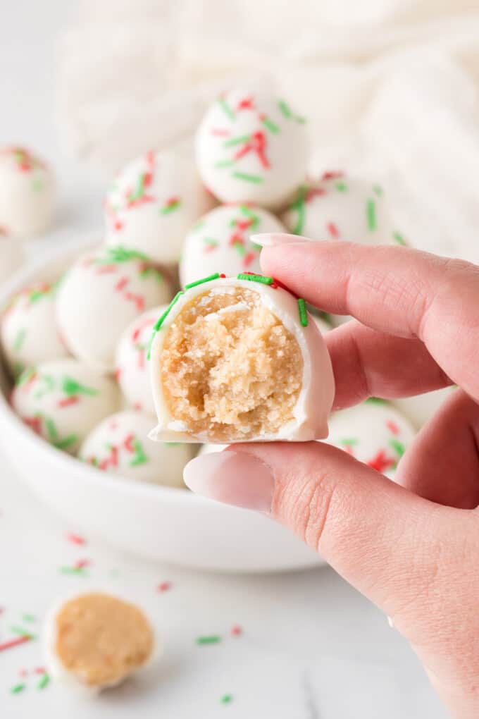 hand holding sugar cookie truffles with bite