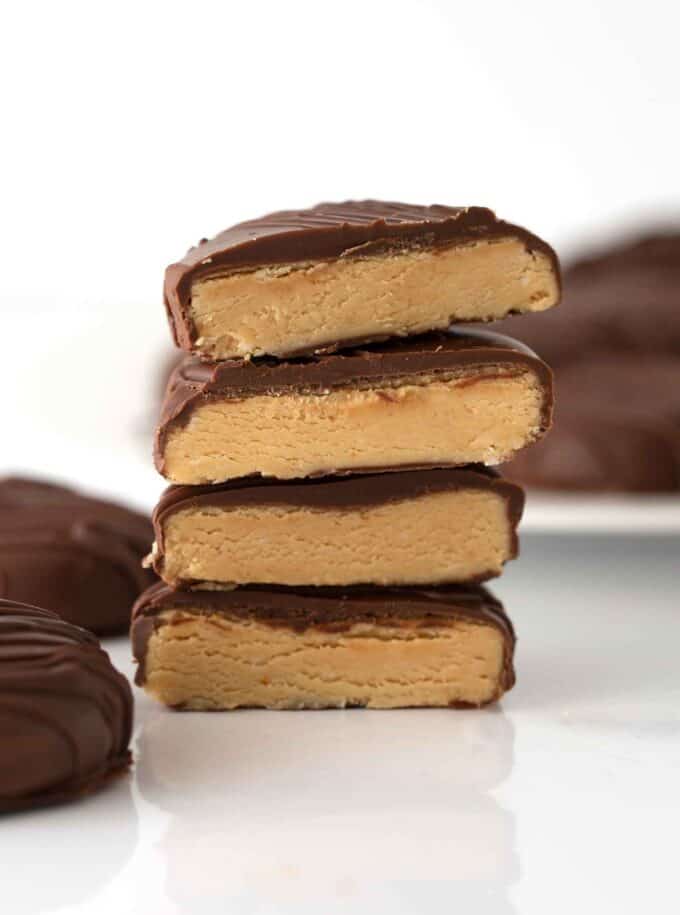 stacked homemade peanut butter eggs cut in half to show creamy texture