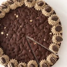 Overhead view of decorated Oreo pizza cookie cake with one slice cut