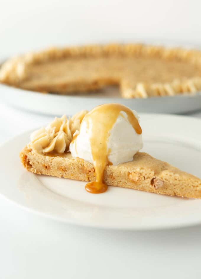 Slice of butterscotch chip cookie cake with scoop of vanilla icecream and caramel sauce