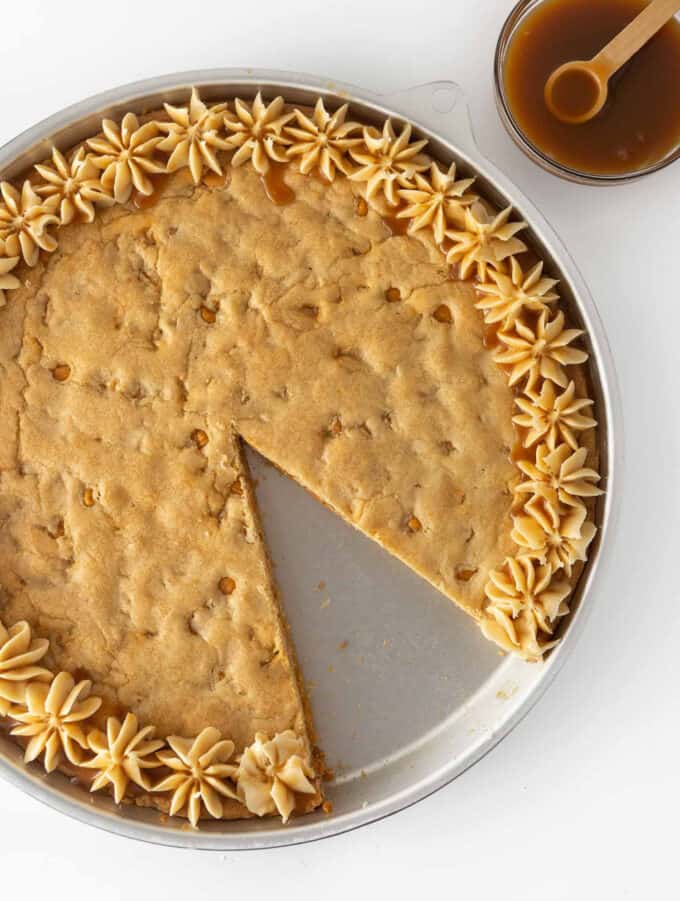 Round butterscotch cookie cake with slice taken out