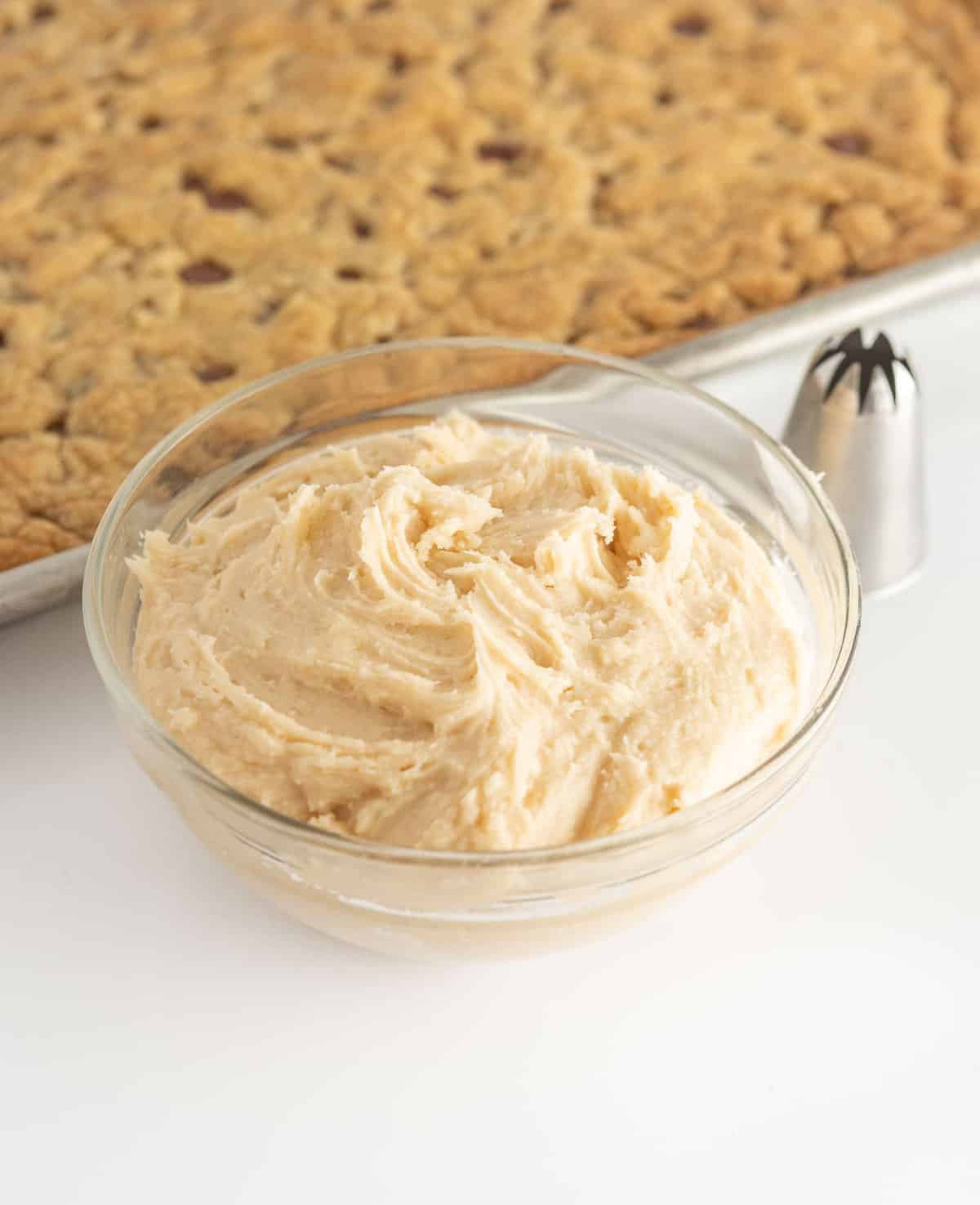 glass bowl of vanilla frosting with large star tip