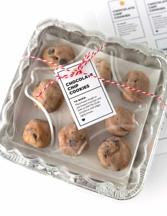 square foil pan filled with chocolate chip cookies and wrapped with twine and a gift tag