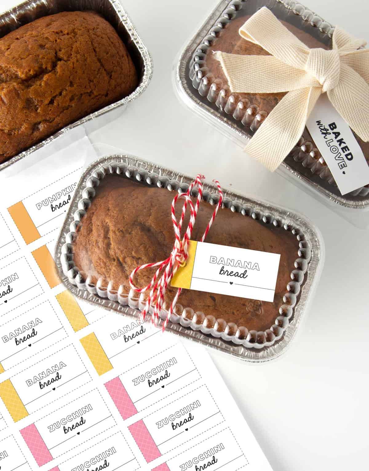 Mini foil loaf pans with banana bread and gift tag wrapped around that says "banana bread"