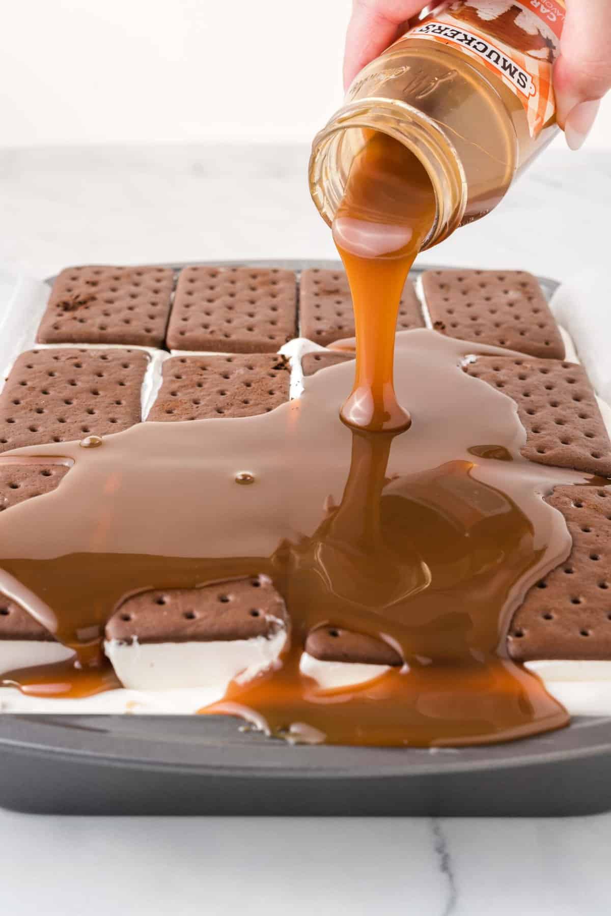 Pouring caramel sauce onto ice cream sandwich cake