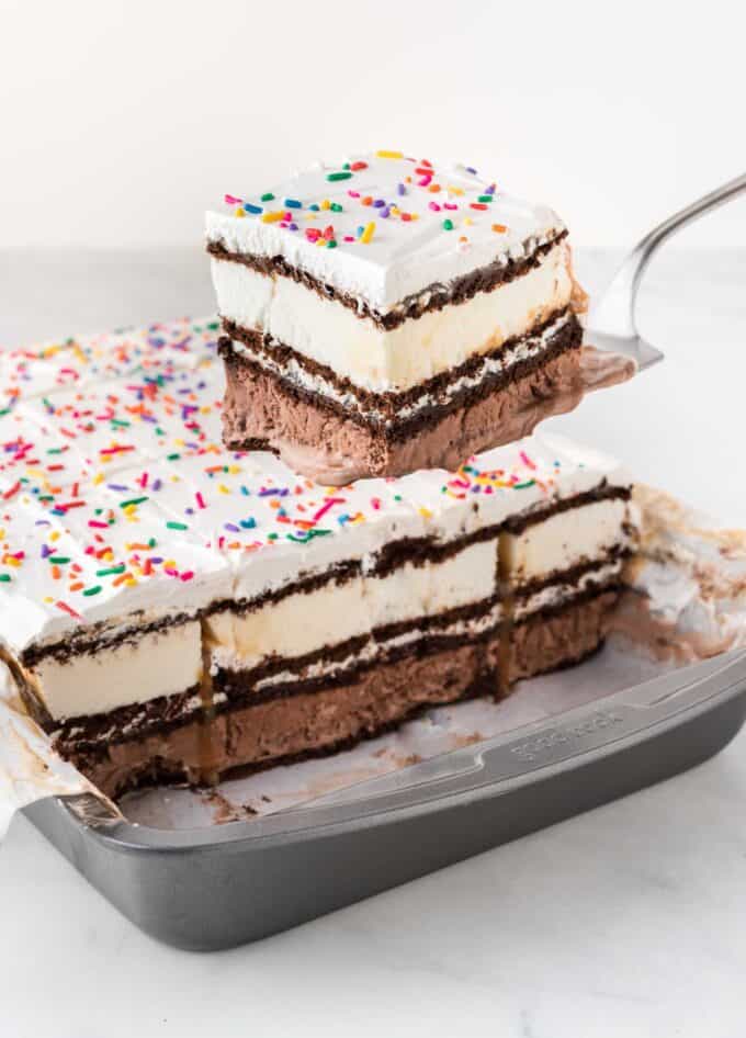 Spatula removing square of ice cream sandwich cake from pan