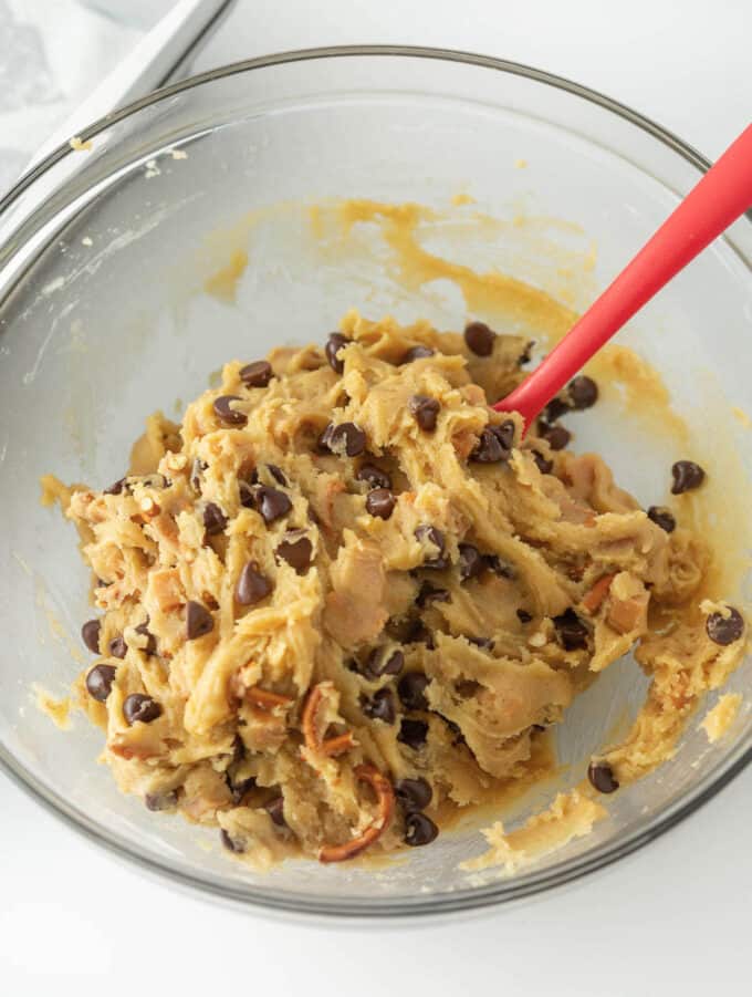 bowl of mixed kitchen sink cookie dough with pretzels, chopped caramel, and chocolate chips