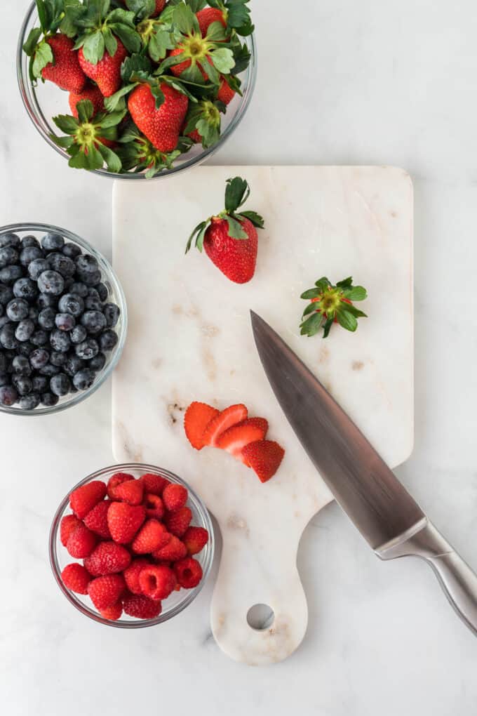slicing strawberries on a cutting board