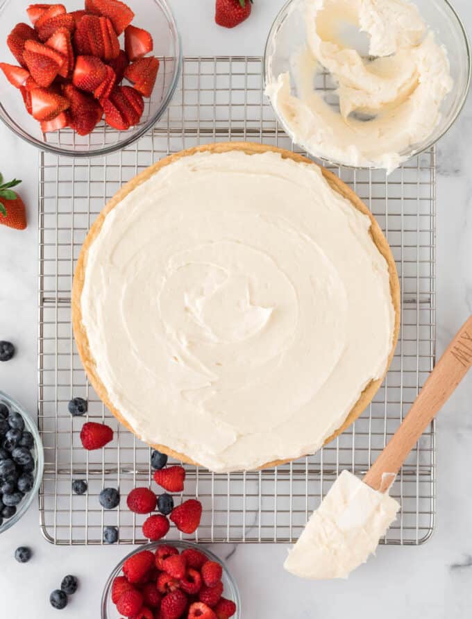 sugar cookie pizza with cream cheese frosted spreaded before adding berries
