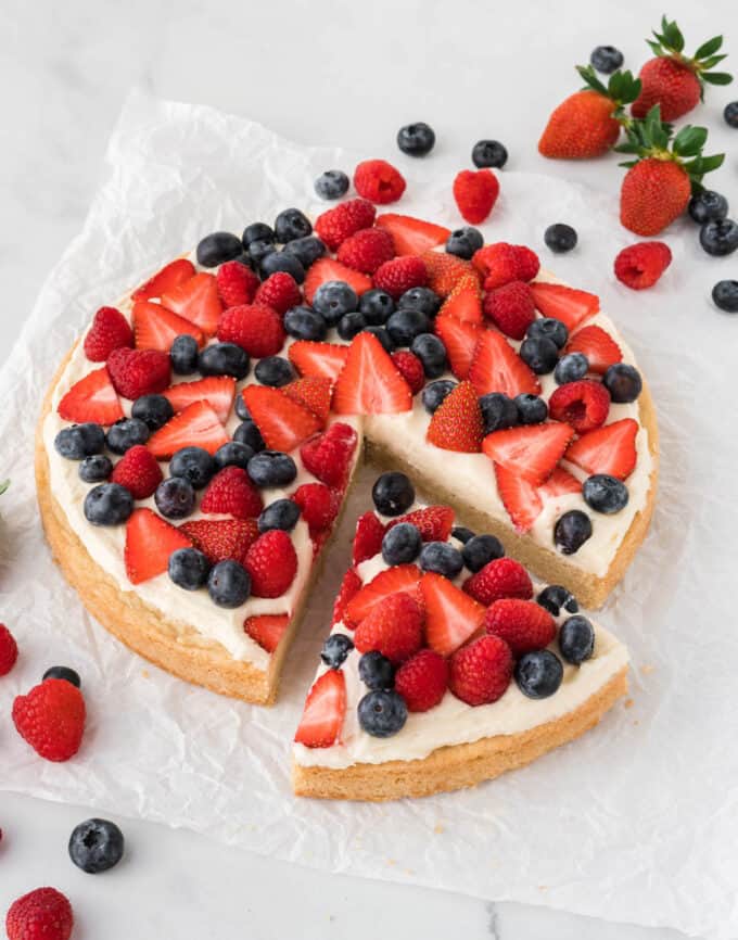 sliced sugar cookie berry pizza topped with strawberries, blueberries, and raspberries