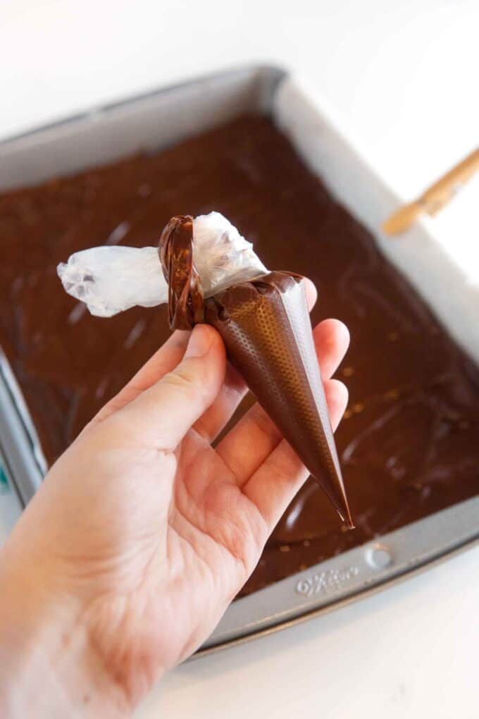 hand holding small piping bag of chocolate