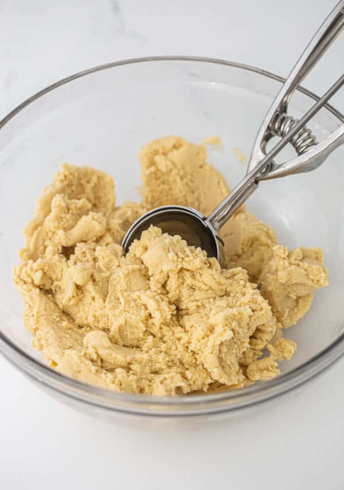 bowl of peppermint sugar cookie dough with cookie scoop