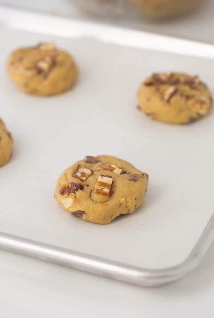 cookie sheet with cookies rolled into balls and slightly flattened