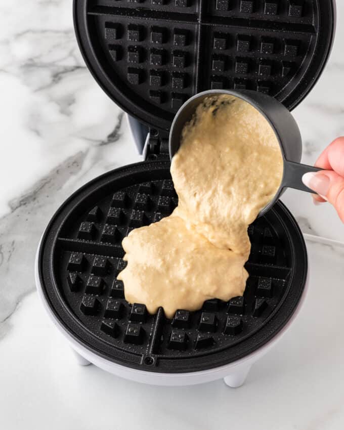 crispy waffle batter being poured into waffle iron