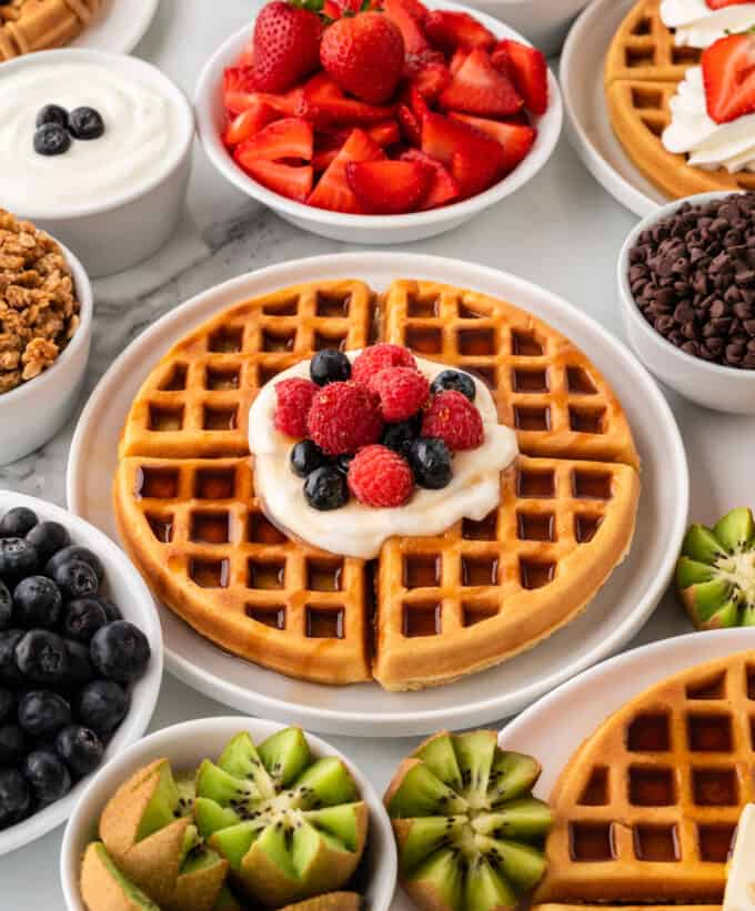 crispy belgian waffle topped with syrup, whipped cream, and mixed berries