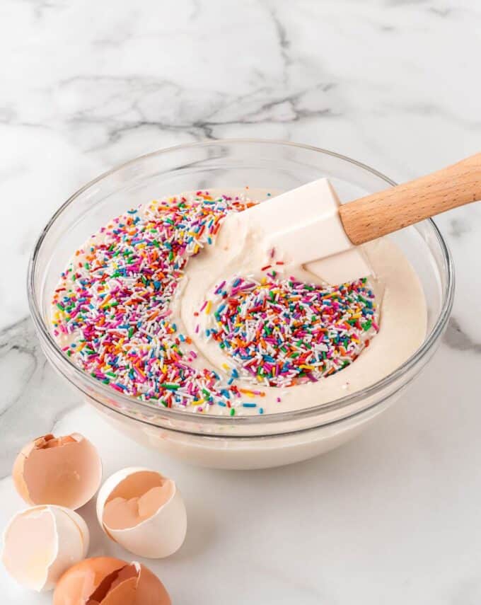 mixing rainbow sprinkles in vanilla cake batter