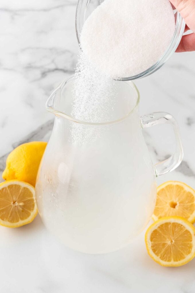 pouring granulated sugar into pitcher