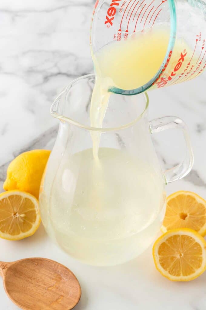 pouring fresh lemon juice in pitcher