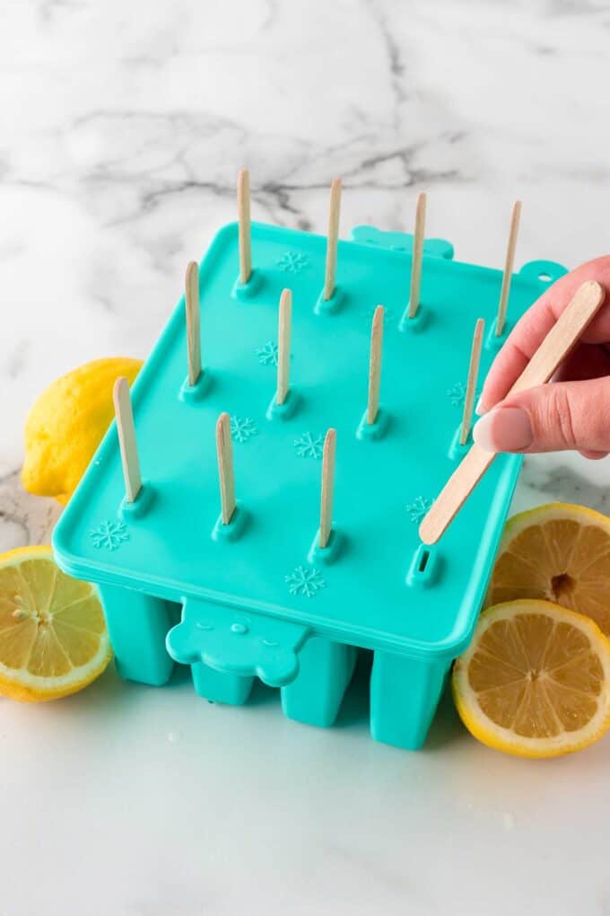 sticking popsicle sticks into silicon popsicle mold