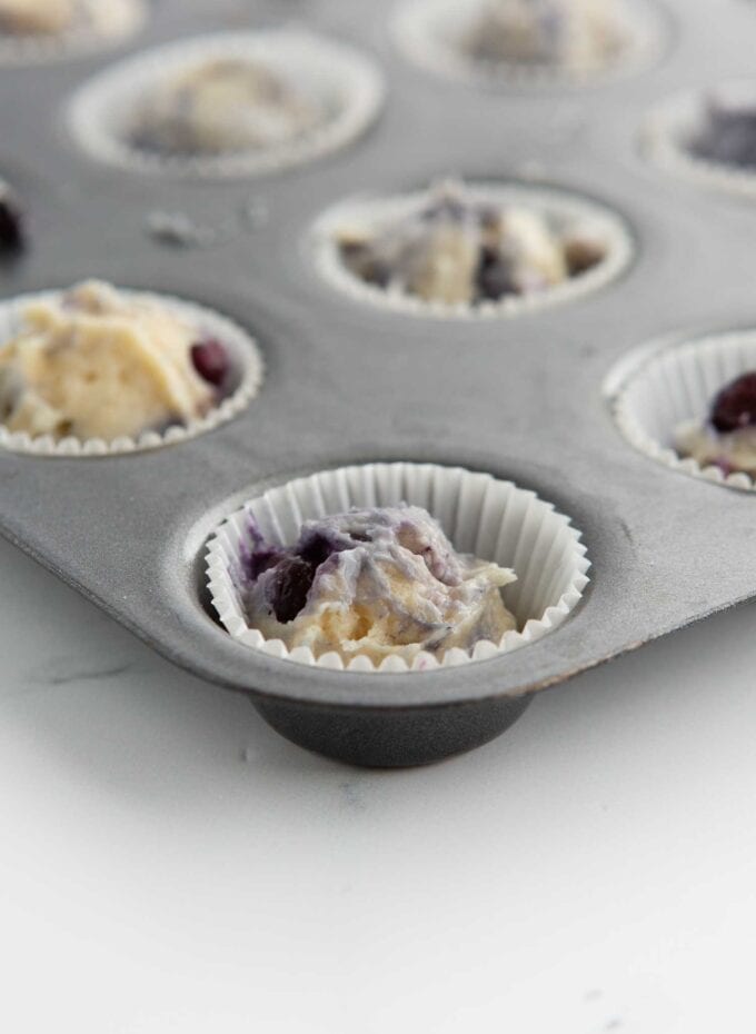 mini blueberry muffin batter in paper liner in mini muffin pan