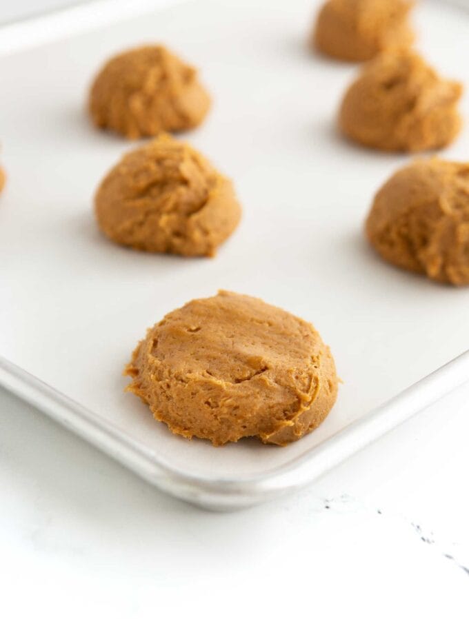 pumpkin cookie dough balls on cookie sheet