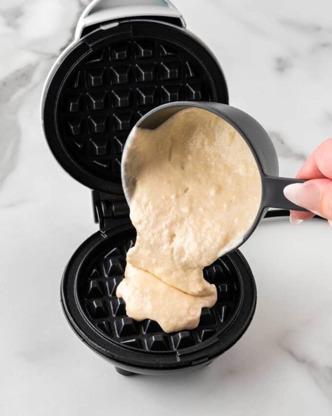 pouring waffle batter in mini dash waffle maker