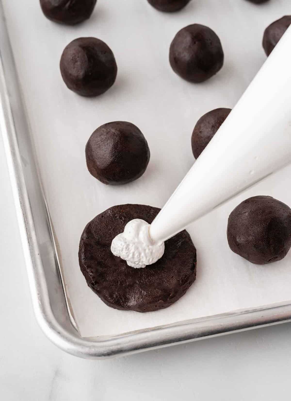 piping marshmallow fluff inside oreo truffle ball