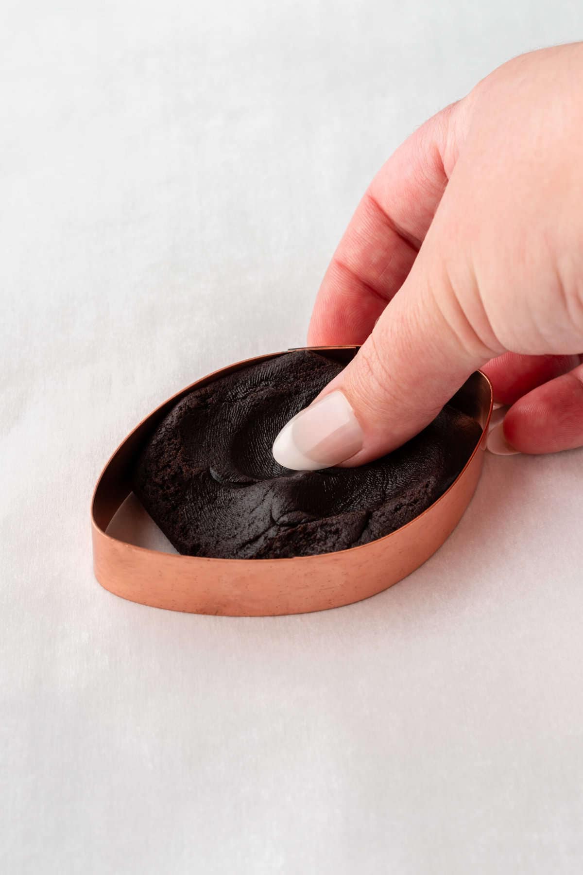pressing dough into football cookie cutter