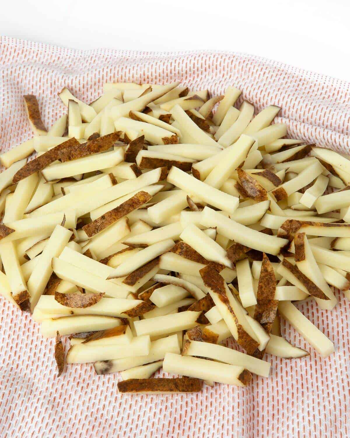 cut potatoes drying on kitchen towel