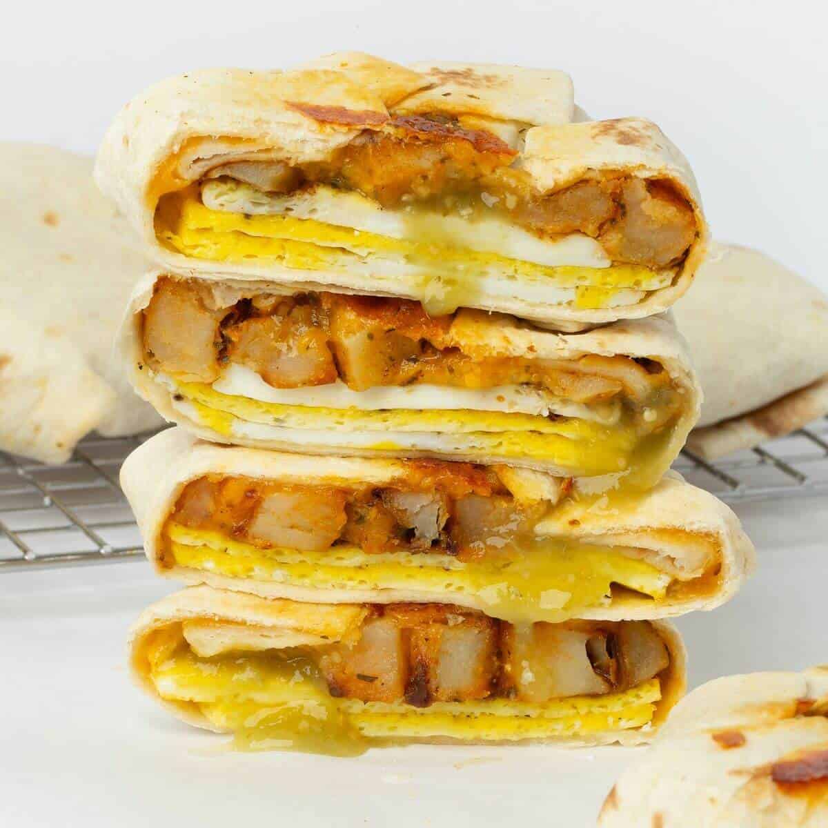 two breakfast crunchwraps cut in half stacked on top of each other