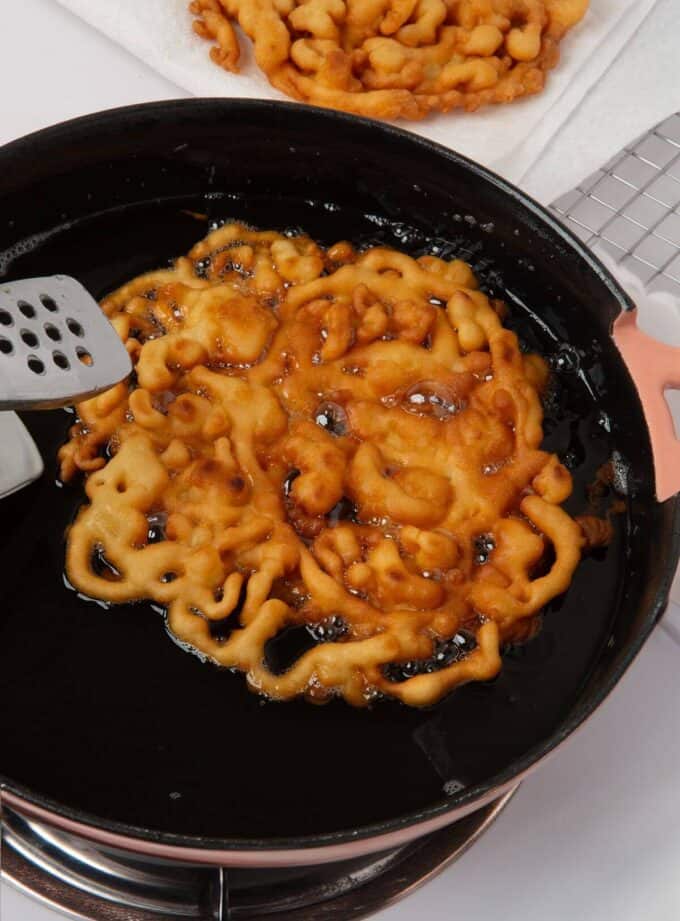 funnel cake frying in oil in skillet