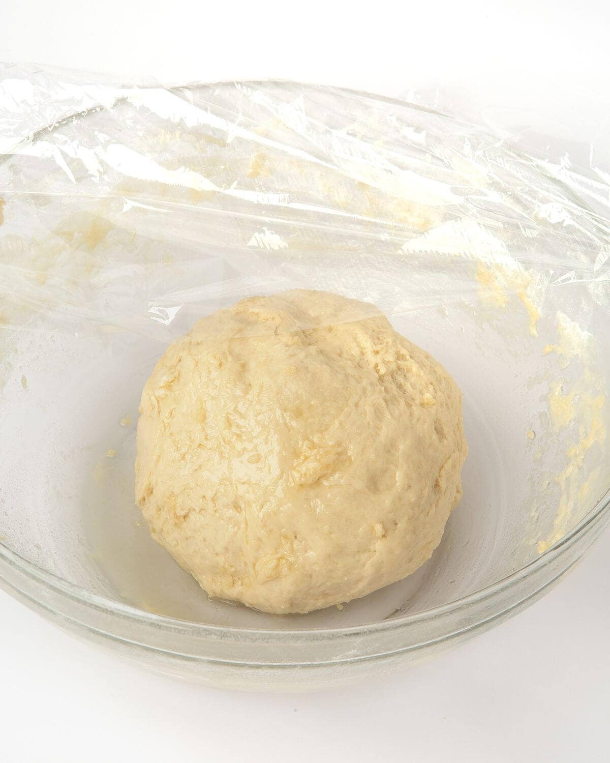 pretzel bite dough in bowl with plastic wrap