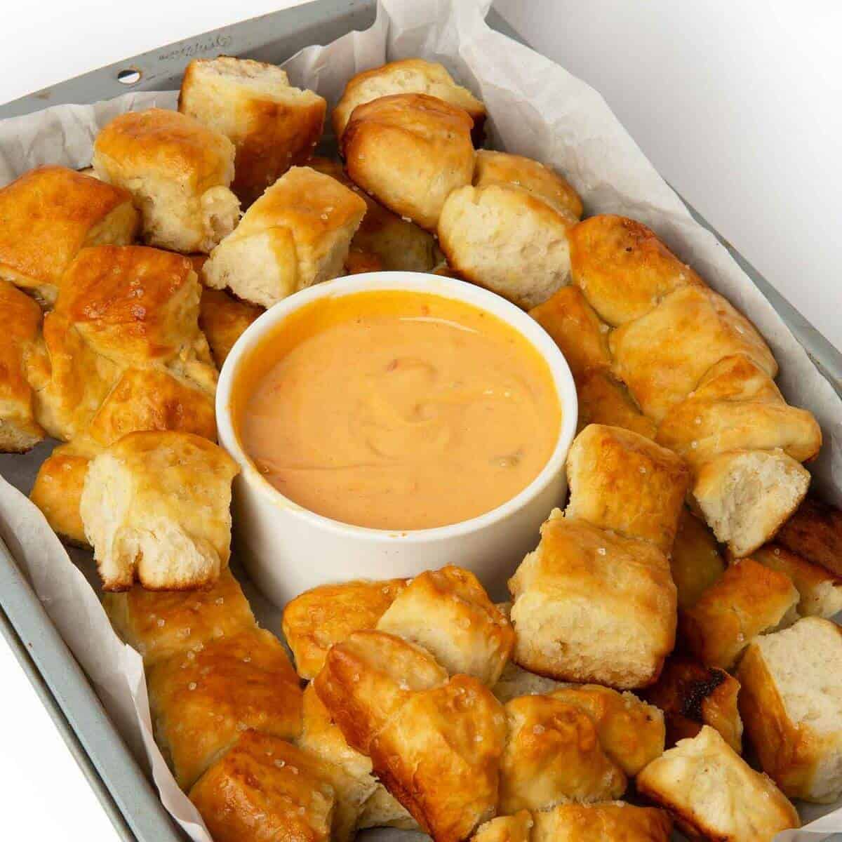 pretzel bite monkey bread in tray with cheese dipping sauce