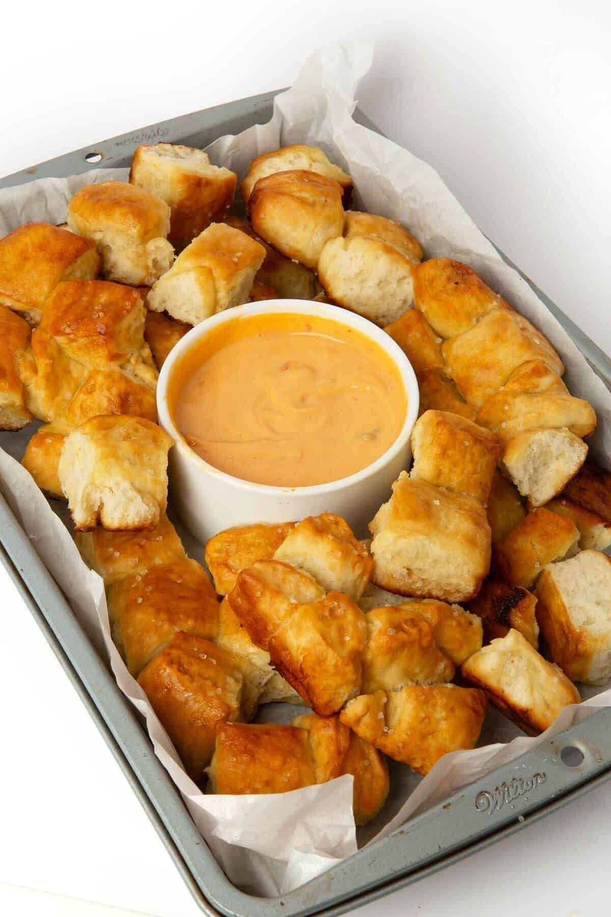 pretzel bite monkey bread in tray with cheese dipping sauce