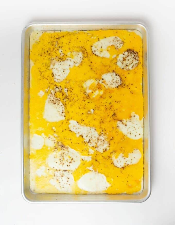 sheet pan eggs on baking sheet seasoned with salt and pepper