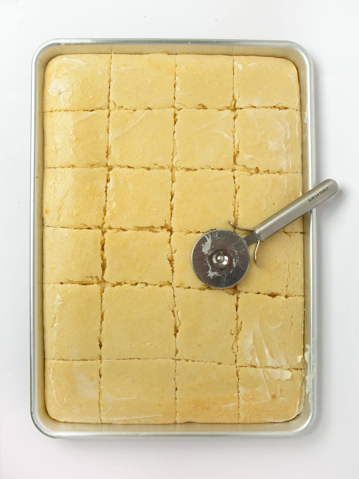 sheet pan pancakes on rimmed baking sheet sliced with pizza cutter