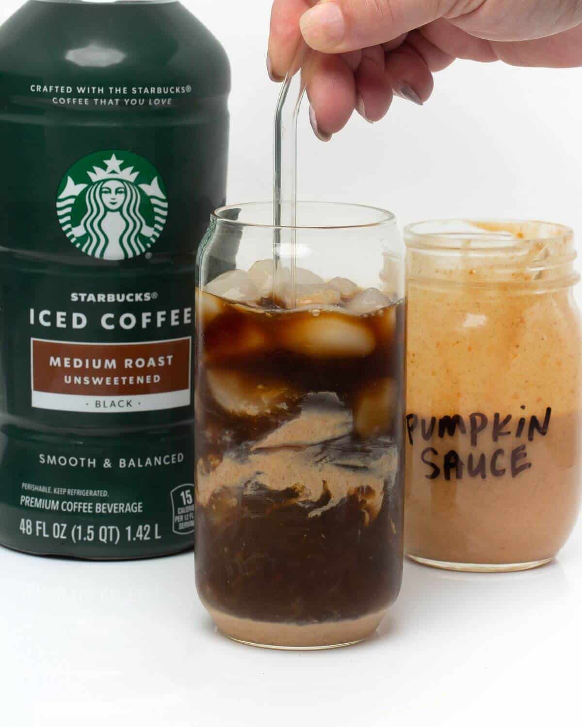 stirring pumpkin cream and cold brew in glass