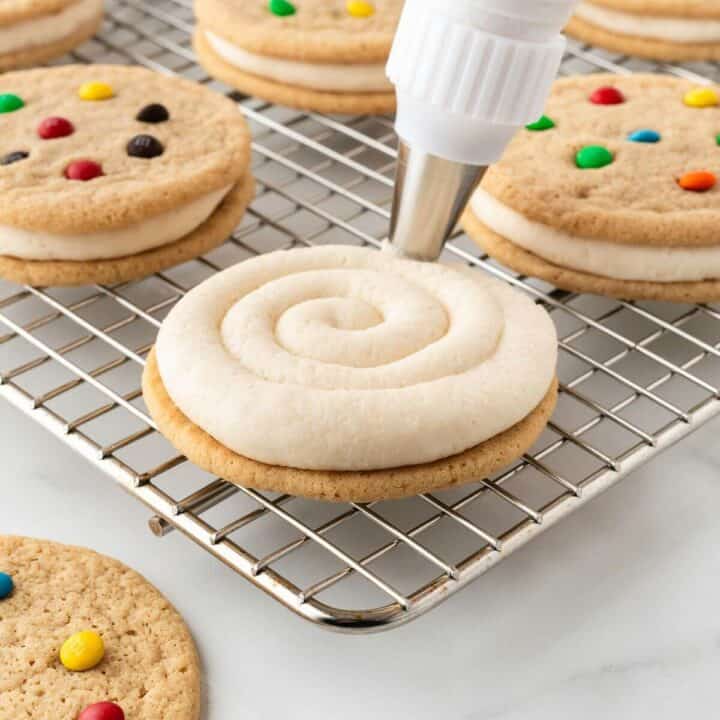 Piping frosting on cookie for cookie sandwich.