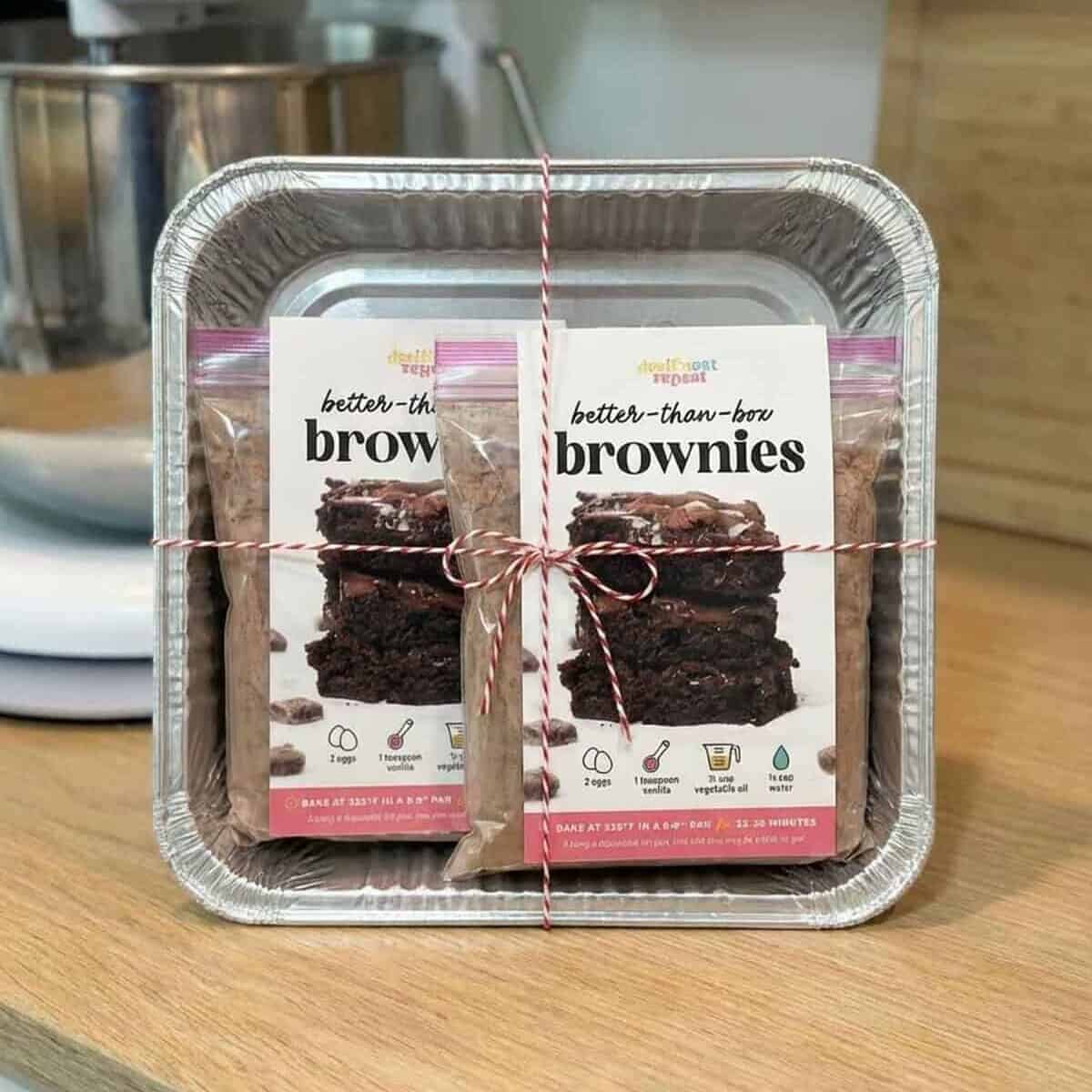 Homemade brownie mix portioned into foil baking pans tied with ribbon as a ready-to-bake gift