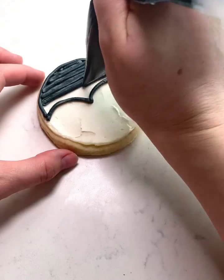 Filling in the penguin's head with black buttercream