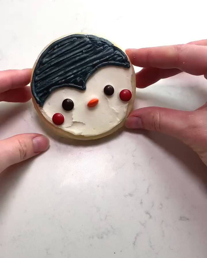 Penguin cookie with candy eyes, red cheeks and an orange nose